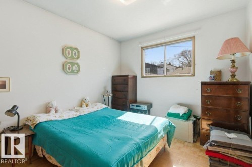The room features a window providing natural light, light-colored walls, and a wood floor - 10459 66 Avenue, Edmonton, AB - Indoor Photo Showing Bedroom