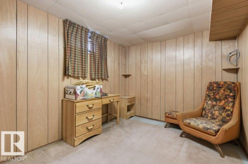The room features light-toned wood paneling on the walls and a window with patterned curtains - 10459 66 Avenue, Edmonton, AB - Indoor Photo Showing Other Room