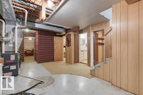 The finished basement features a combination of concrete flooring and carpeting, with wood paneling on the walls - 10459 66 Avenue, Edmonton, AB - Indoor Photo Showing Other Room