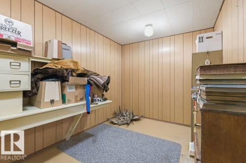 This versatile space features wood paneling on the walls and a paneled ceiling with a central light fixture - 10459 66 Avenue, Edmonton, AB - Indoor Photo Showing Other Room