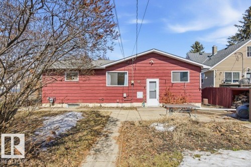The property features a red exterior with a white entry door and white-framed windows - 10459 66 Avenue, Edmonton, AB - Outdoor