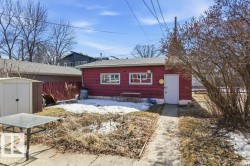 The property includes a detached red outbuilding with a white door and two windows - 