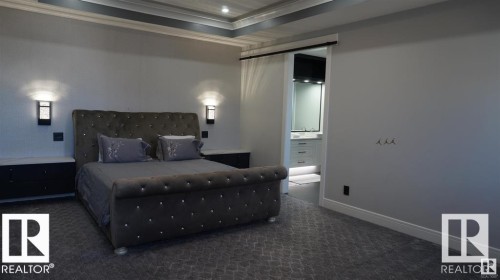 Bedroom featuring a carpeted floor, wall-mounted light fixtures, and a sliding barn door - 707 180 Street, Edmonton, AB - Indoor Photo Showing Bedroom