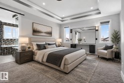 Spacious room featuring tray ceilings, recessed lighting, and large windows with privacy blinds - 