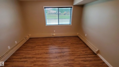 This room features durable wood-look flooring and neutral-toned walls - 2103 1601 8 Avenue, Cold Lake, AB - Indoor Photo Showing Other Room