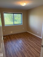 Room featuring wood-finish flooring, a window with horizontal blinds, and a flush mount ceiling light fixture - 
