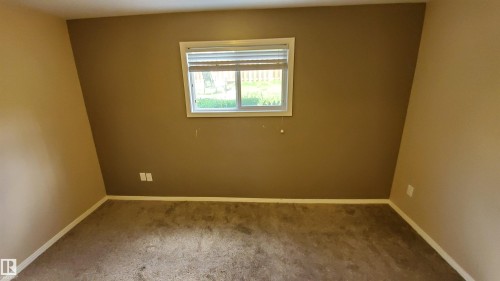 This room features a window providing natural light, carpeted flooring, and neutral wall tones - 2103 1601 8 Avenue, Cold Lake, AB - Indoor Photo Showing Other Room