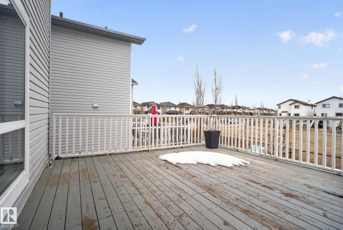 The property features a spacious outdoor deck with wood planks and a white railing - 96 Dalquist Bay, Leduc, AB - Outdoor With Deck Patio Veranda With Exterior