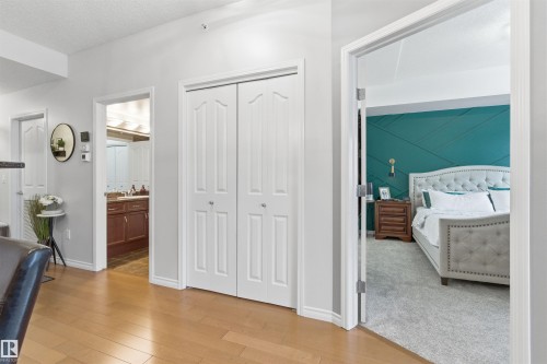The property features light hardwood flooring and white bi-fold doors - 316 141 Festival Way, Sherwood Park, AB - Indoor Photo Showing Bedroom