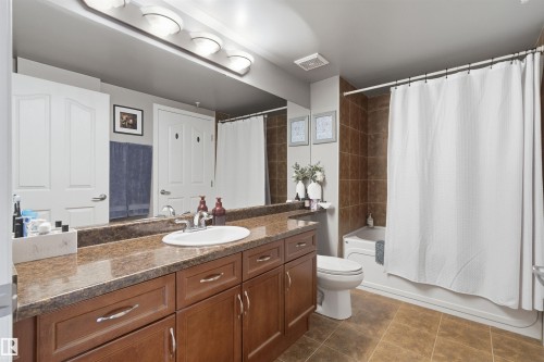 The property features a bathroom with a vanity, an integrated sink, and a large mirror - 316 141 Festival Way, Sherwood Park, AB - Indoor Photo Showing Bathroom