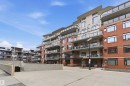 The property features a multi-story exterior with brick and light-colored siding, complemented by glass-paneled balconies - 316 141 Festival Way, Sherwood Park, AB  - Outdoor With Balcony With Facade 