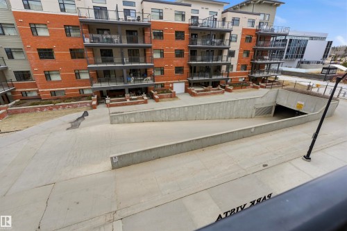 The property features a brick exterior with dark-framed windows and glass-paneled balconies - 316 141 Festival Way, Sherwood Park, AB - Outdoor With Balcony