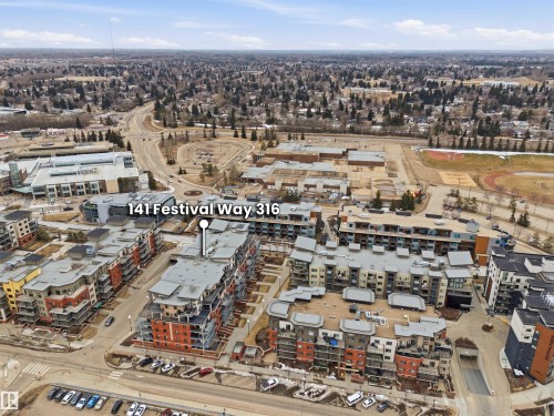 Aerial view of the property and its surrounding development, showcasing several multi-story buildings with varied architectural details and visible balconies - 316 141 Festival Way, Sherwood Park, AB - Outdoor With View