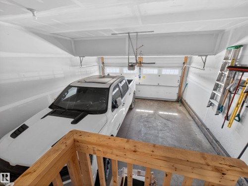 The property features an attached garage with a white overhead door and concrete flooring - 3210 Chernowski Way, Edmonton, AB - Indoor Photo Showing Garage