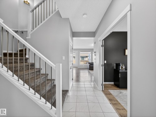 Entryway featuring a staircase with carpeted treads and metal balusters - 3210 Chernowski Way, Edmonton, AB - Indoor Photo Showing Other Room