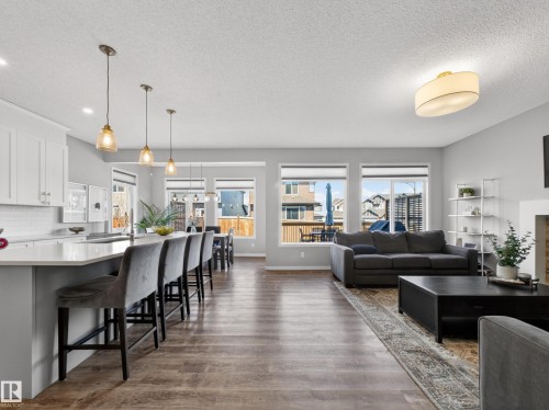 Open concept living area featuring hardwood flooring, recessed lighting, and large windows providing natural light - 3210 Chernowski Way, Edmonton, AB - Indoor