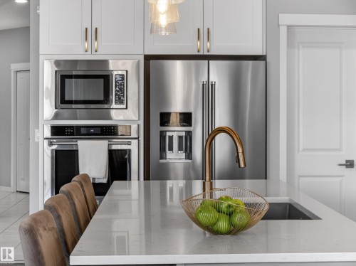 The kitchen features stainless steel appliances, including a microwave, oven, and refrigerator - 3210 Chernowski Way, Edmonton, AB - Indoor Photo Showing Kitchen With Stainless Steel Kitchen With Upgraded Kitchen