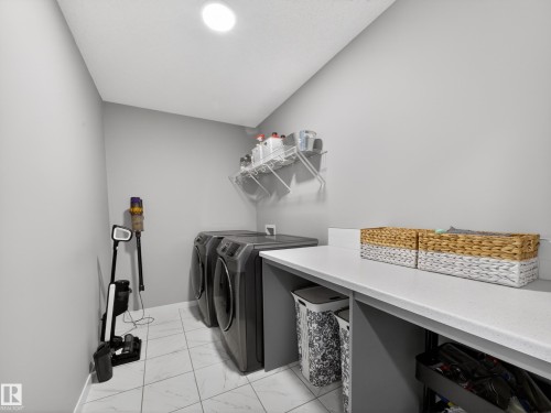 Laundry room featuring a white tile floor, light gray walls, and a recessed ceiling light - 3210 Chernowski Way, Edmonton, AB - Indoor Photo Showing Laundry Room