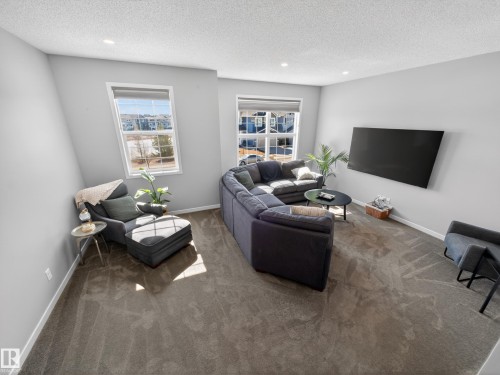 Living area featuring light grey walls, recessed lighting, and carpeted flooring - 3210 Chernowski Way, Edmonton, AB - Indoor Photo Showing Living Room