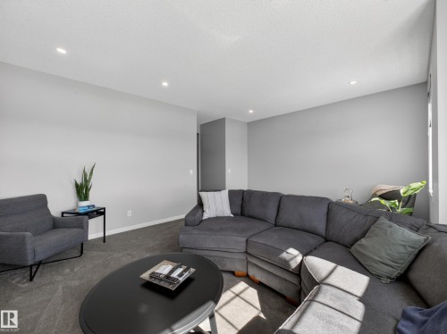 The living room features recessed lighting, light gray walls, and carpeted flooring - 3210 Chernowski Way, Edmonton, AB - Indoor Photo Showing Living Room