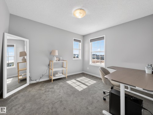 This room features light grey walls and grey carpet flooring - 3210 Chernowski Way, Edmonton, AB - Indoor