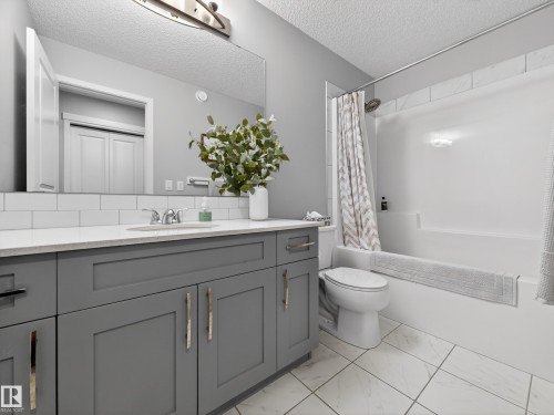 Bathroom featuring a vanity with grey cabinetry, a white countertop, and a rectangular sink - 3210 Chernowski Way, Edmonton, AB - Indoor Photo Showing Bathroom