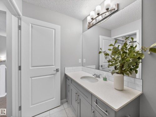 Bathroom vanity featuring a light-colored countertop, a rectangular sink, and grey cabinetry with silver hardware - 3210 Chernowski Way, Edmonton, AB - Indoor Photo Showing Bathroom