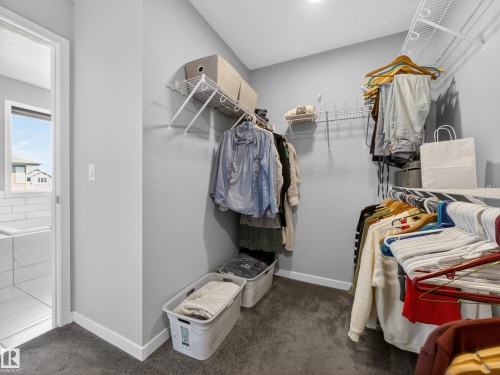 The property features a walk-in closet with carpeted flooring and white wire shelving, offering ample storage space - 3210 Chernowski Way, Edmonton, AB - Indoor With Storage