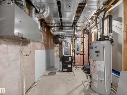 The property features a utility room with exposed ductwork, a furnace, and a water heater - 3210 Chernowski Way, Edmonton, AB - Indoor Photo Showing Basement