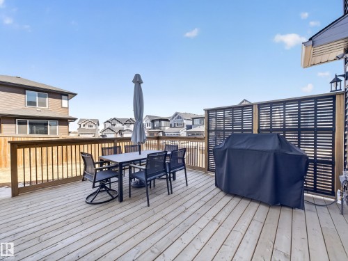 The property features an outdoor deck with wood flooring and a privacy screen - 3210 Chernowski Way, Edmonton, AB - Outdoor With Deck Patio Veranda With Exterior