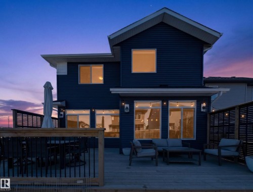 The property features a spacious rear deck with railings, offering an ideal setting for outdoor enjoyment - 3210 Chernowski Way, Edmonton, AB - Outdoor With Deck Patio Veranda