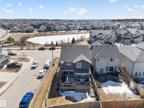 The property features a dark gray exterior, a deck with a patio set, and a fenced yard - 3210 Chernowski Way, Edmonton, AB - Outdoor