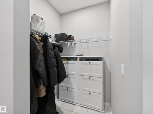 The property features a closet with a built-in storage unit, wire shelving, and a hanging rod - 3210 Chernowski Way, Edmonton, AB - Indoor