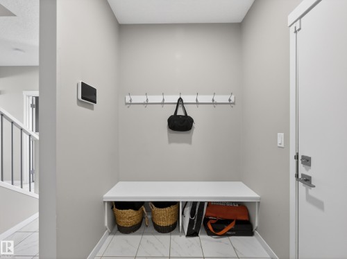 Entryway featuring a built-in bench with storage, coat hooks, and tiled flooring - 3210 Chernowski Way, Edmonton, AB - Indoor