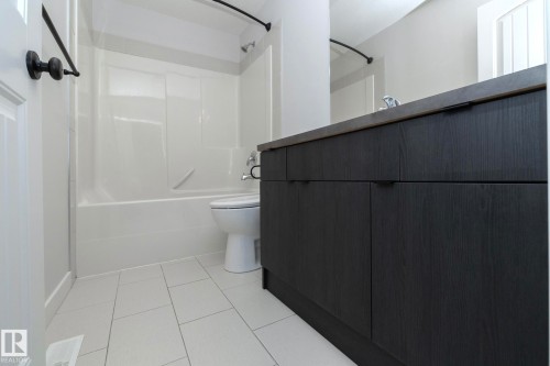 The bathroom features a vanity with dark wood-grain cabinetry and a contrasting countertop - 197 Birchwood Close, Devon, AB - Indoor Photo Showing Bathroom