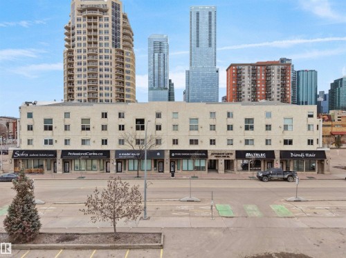 The property features a brick exterior with large windows on the upper levels and storefront windows on the ground floor - 10 10331 106 Street, Edmonton, AB - Outdoor With Facade