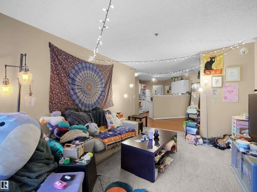 The living area features light-colored carpeting, warm-toned walls, and a recessed ceiling - 10 10331 106 Street, Edmonton, AB - Indoor