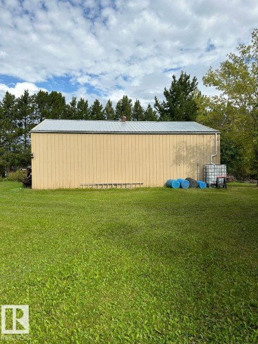 The property features a metal-sided building with a metal roof, set on a grassy expanse - Lot 118 Homestead Trail, Rural St. Paul County, AB 