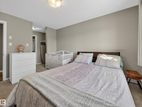 The room features neutral-toned walls and carpeted flooring, providing a versatile backdrop - 124 148 Ebbers Boulevard, Edmonton, AB - Indoor Photo Showing Bedroom