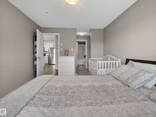 The bedroom features neutral-toned walls and a ceiling light fixture - 124 148 Ebbers Boulevard, Edmonton, AB - Indoor Photo Showing Bedroom