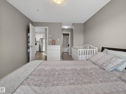 The bedroom features neutral-toned walls and a ceiling light fixture - 