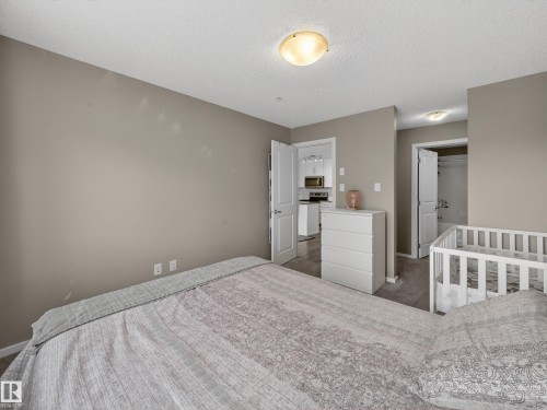 The bedroom features neutral-toned walls, carpet flooring, and a ceiling light fixture - 124 148 Ebbers Boulevard, Edmonton, AB - Indoor Photo Showing Bedroom