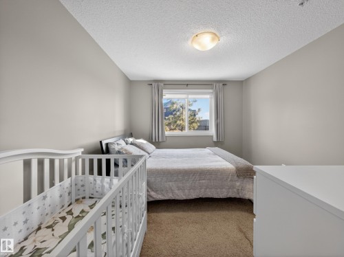 This room features neutral-toned walls, a window with curtains, and carpeting - 124 148 Ebbers Boulevard, Edmonton, AB - Indoor Photo Showing Bedroom