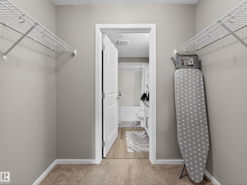 Walk-in closet with carpeted flooring and wire shelving - 124 148 Ebbers Boulevard, Edmonton, AB - Indoor With Storage