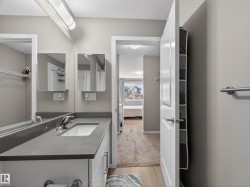 Bathroom featuring a vanity with a white rectangular sink and chrome faucet, under-sink storage, and a mirror extending across the length of the vanity - 