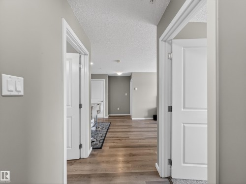 The property features light gray walls and wood flooring, complemented by white doors and trim - 124 148 Ebbers Boulevard, Edmonton, AB - Indoor Photo Showing Other Room