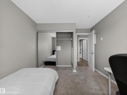 Bedroom with neutral-toned carpet flooring and light gray walls - 