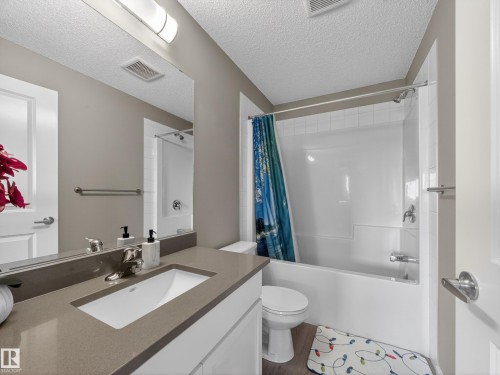 Bathroom featuring a vanity with a rectangular sink, a bathtub with a shower, and a toilet - 124 148 Ebbers Boulevard, Edmonton, AB - Indoor Photo Showing Bathroom