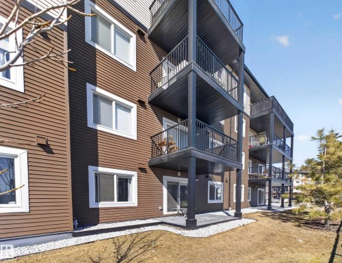 The property features a modern exterior with brown horizontal siding and white trim windows - 124 148 Ebbers Boulevard, Edmonton, AB - Outdoor