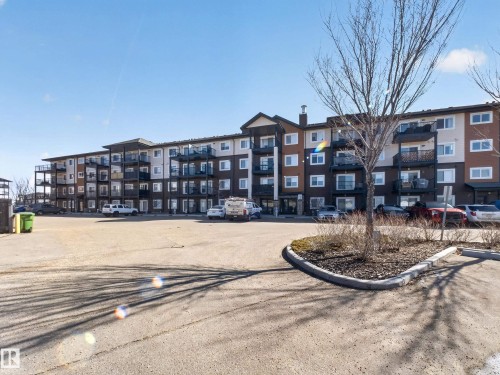 The property features a multi-story building with a brown, cream, and dark grey exterior, complete with balconies and numerous windows - 124 148 Ebbers Boulevard, Edmonton, AB - Outdoor With Facade